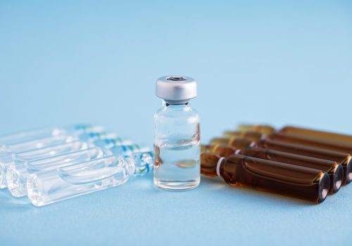 A closeup of vaccine vials over a blue background. Vaccine, medicine, protection, COVID19, coronavirus concept